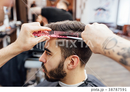 man getting trendy haircut at barber shop. man getting trendy haircut at barber shop. 38787591