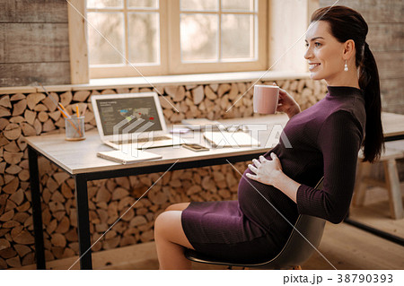 Ambitious pregnant businesswoman relaxing with tea Ambitious pregnant businesswoman relaxing with tea 38790393