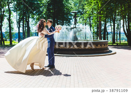 Beautiful couple newlyweds near the fountain Beautiful couple newlyweds near the fountain 38791109