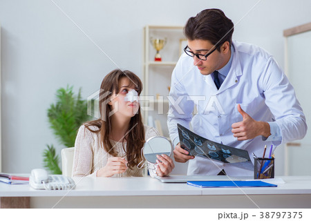 Male doctor talking to patient with nose operation 38797375