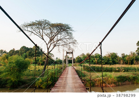 Wooden suspension bridge cross over small river Wooden suspension bridge cross over small river 38798299