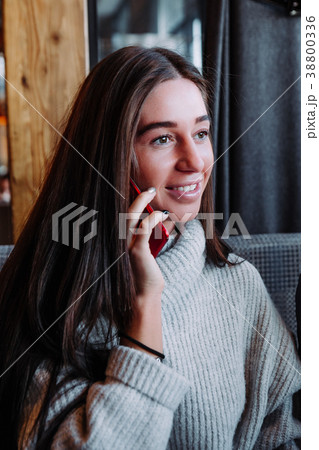 brunette businesswoman in sweater talking on the brunette businesswoman in sweater talking on the 38800336