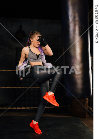 Young woman trains in boxing ring with heavy 38801941
