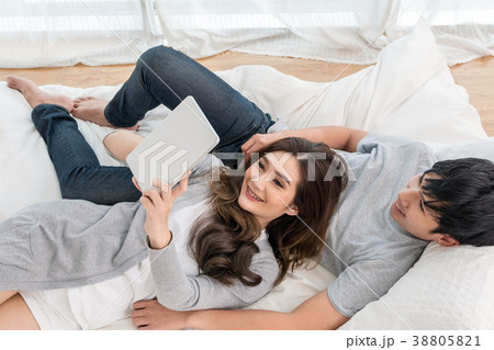 Top view of Lover using the digital tablet at modern home sleeping on the bed, Couple Lover and lifestyle concept Top view of Lover using the digital tablet at modern home sleeping on the bed, Couple Lover and lifestyle concept 38805821