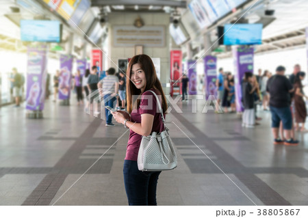 Asian woman passenger with casual suit using the smart mobile phone at the interexchange between station of Skytrain rails or subway for travel in the big city, lifestyle and transportation concept Asian woman passenger with casual suit using the smart mobile phone at the interexchange between station of Skytrain rails or subway for travel in the big city, lifestyle and transportation concept 38805867
