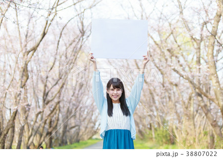 公園でメッセージボードを持つ若い女性　春 38807022