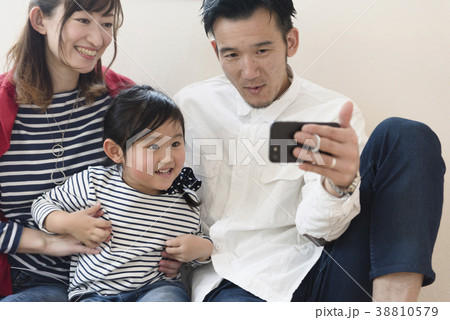 子供にスマートフォンを見せる父親 38810579