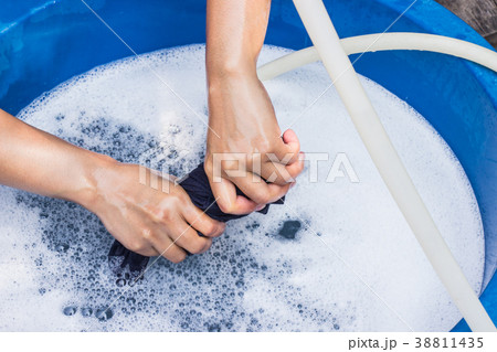 Female hands wash clothing by hand with detergent Female hands wash clothing by hand with detergent 38811435