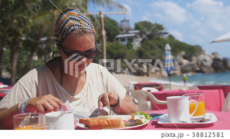 Woman in sunglasses spreads bread toasts with Woman in sunglasses spreads bread toasts with 38812581
