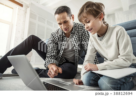 Alert father sitting on the floor with his son Alert father sitting on the floor with his son 38812694