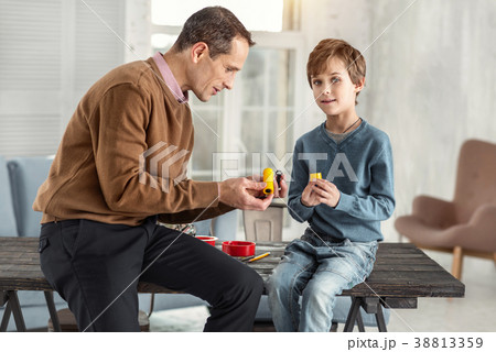 concentrated daddy showing instruments to his sonの写真素材