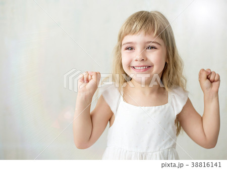 Portrait of pretty little girl in white dress. 38816141