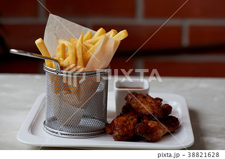 Chicken wings with sauce ketchup and fries in a 38821628