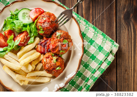 Roasted meatballs in tomato sauce with fries 38823382