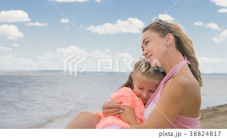 Little cute girl and young mother at beach. 38824817