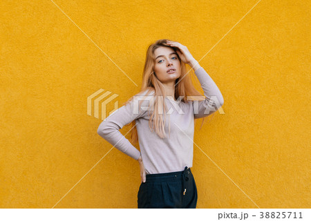 girl posing against a yellow wall, street style girl posing against a yellow wall, street style 38825711
