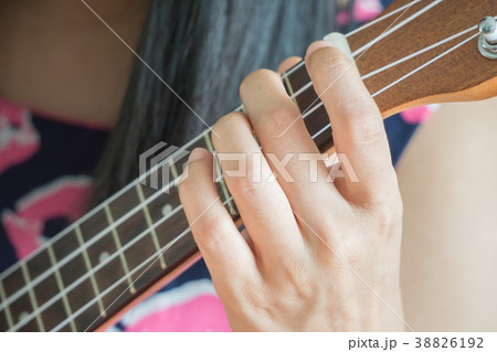 close up hand playing guitar or Ukulele chord. close up hand playing guitar or Ukulele chord. 38826192
