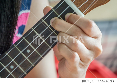 close up hand playing guitar or Ukulele chord. 38826193