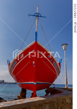 Chora. Mykonos. Red fishing boat on the shore. 38827232
