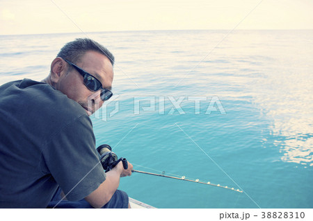 man and fishing rod in hand with wide blue sea 38828310