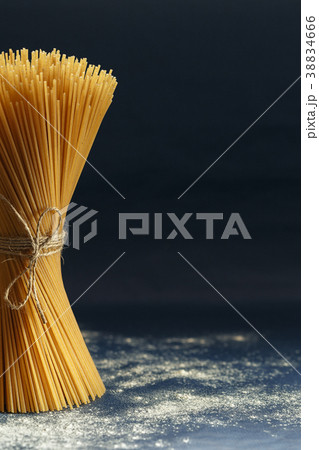 Uncooked pasta spaghetti on a blue background Uncooked pasta spaghetti on a blue background 38834666