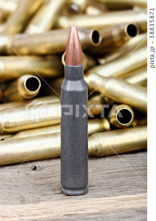 Close-up photo of bullet on the wooden table. 38835871