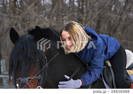 A young girl with white hair is riding a horse. 38836986