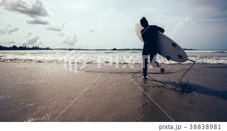 woman surfer with surfboard running on beach 38838981