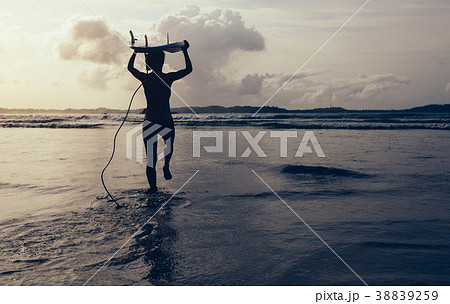 woman surfer with surfboard running on beach woman surfer with surfboard running on beach 38839259