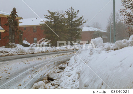A large plowed pile of snow in front of a house A large plowed pile of snow in front of a house 38840022