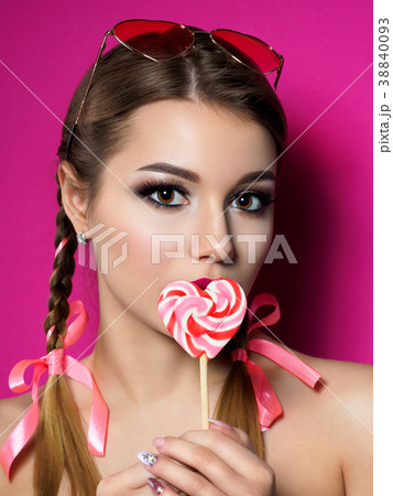 Young beautiful woman holds heart shaped lollipop 38840093