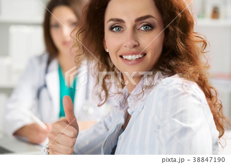 Smiling female patient showing thumb up Smiling female patient showing thumb up 38847190