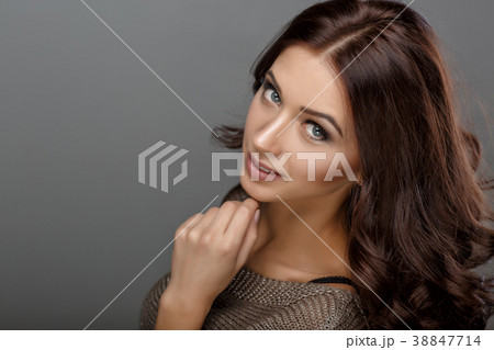 brunette woman with shiny long curly hair 38847714