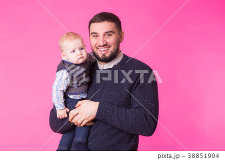 Happy father holding baby son in hands over pink 38851904