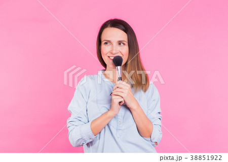Professional makeup artist with brushes on pink Professional makeup artist with brushes on pink 38851922