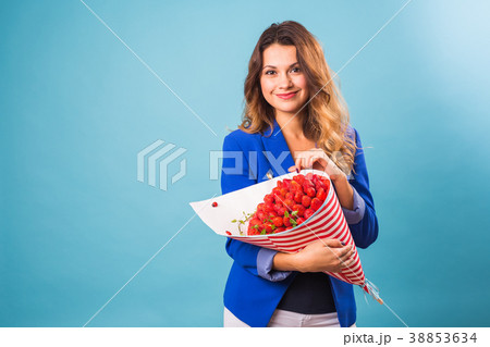 Bouquet of strawberries in the hands of a girl on 38853634