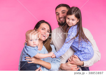 Cute family posing and smiling at camera together 38853897