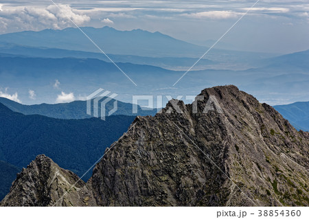 奥穂高岳から見る前穂高岳山頂と八ヶ岳遠望の写真素材