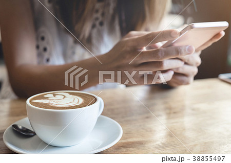 Young woman using smart phone in coffee shop 38855497