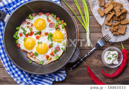 Fred eggs in pan with tomatoes and green fresh 38863033