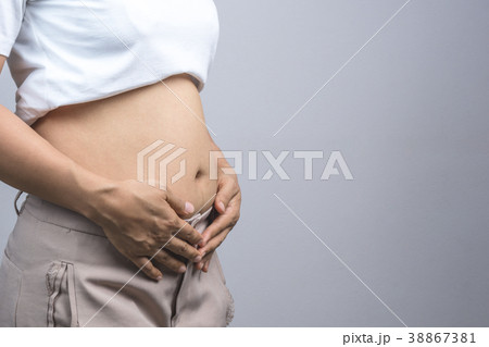 Woman touching her fat belly 38867381
