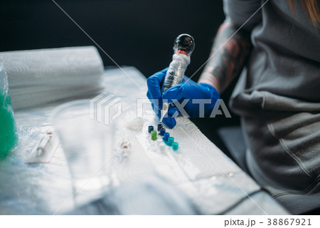 Female tattooist hands holds tattoo machine 38867921