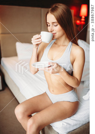 Beautiful woman drinks coffee in bed, good morning Beautiful woman drinks coffee in bed, good morning 38867987