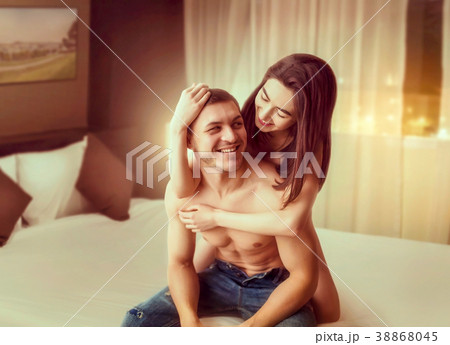 Happy love couple hugging on big white bed Happy love couple hugging on big white bed 38868045