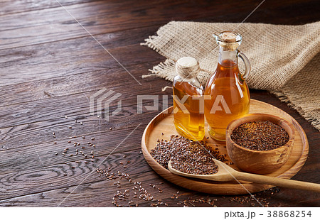 Flax seeds in bowl and flaxseed oil in glass 38868254