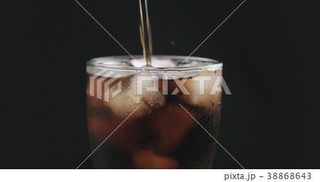 closeup cola pouring into glass with ice 38868643