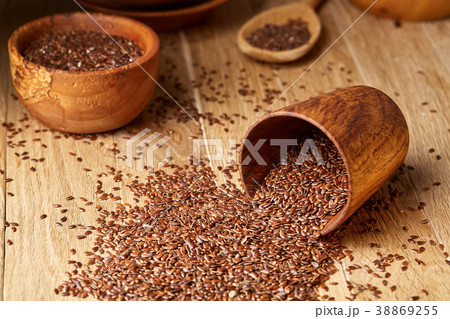 An overturned wooden bowl with linseeds on a An overturned wooden bowl with linseeds on a 38869255