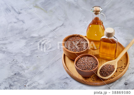 Flax seeds in bowl and flaxseed oil in glass 38869380