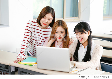 Campus life - female students in a classroom during class, studying together and taking selfie through mobile phone. 241 Campus life - female students in a classroom during class, studying together and taking selfie through mobile phone. 241 38877653