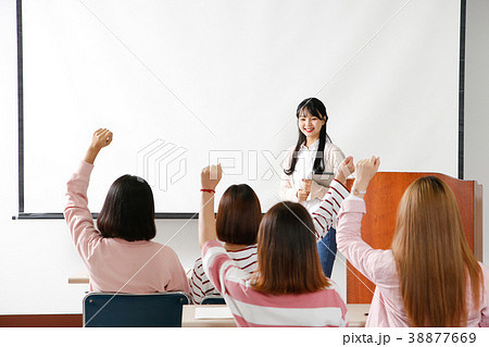 Campus life - female students in a classroom during class, studying together and taking selfie through mobile phone. 252 Campus life - female students in a classroom during class, studying together and taking selfie through mobile phone. 252 38877669